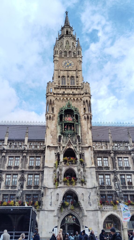 Close-up of the Glockenspiel carillon on the New Town Hall tower at Marienplatz Munich Germany showing the 32 life-sized figures and ornate Neo-Gothic stonework against a blue sky