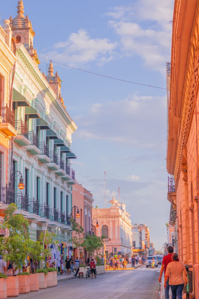 Colorful colonial buildings and busy pedestrian street in historic downtown Mérida, Mexico at golden hour