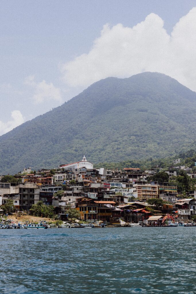 A Lake Atitlán town in Guatemala with a volcano rising behind it, a popular stop after visiting Tikal